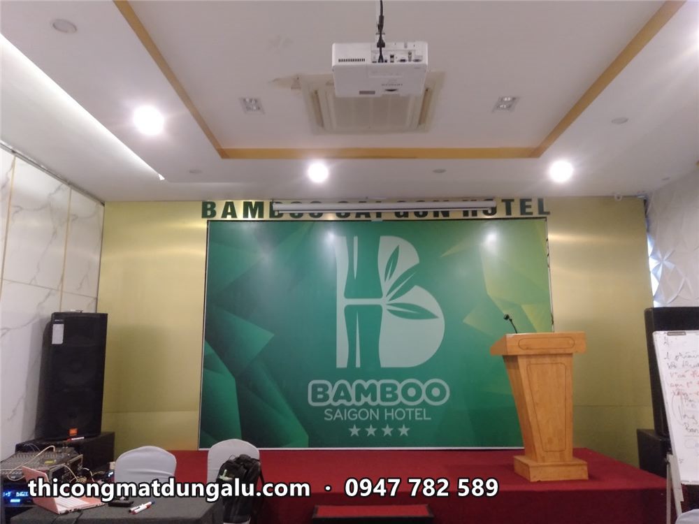 Backdrop hội trường khách sạn Bamboo Saigon hoàn thiện với bục phát biểu gỗ phía trước