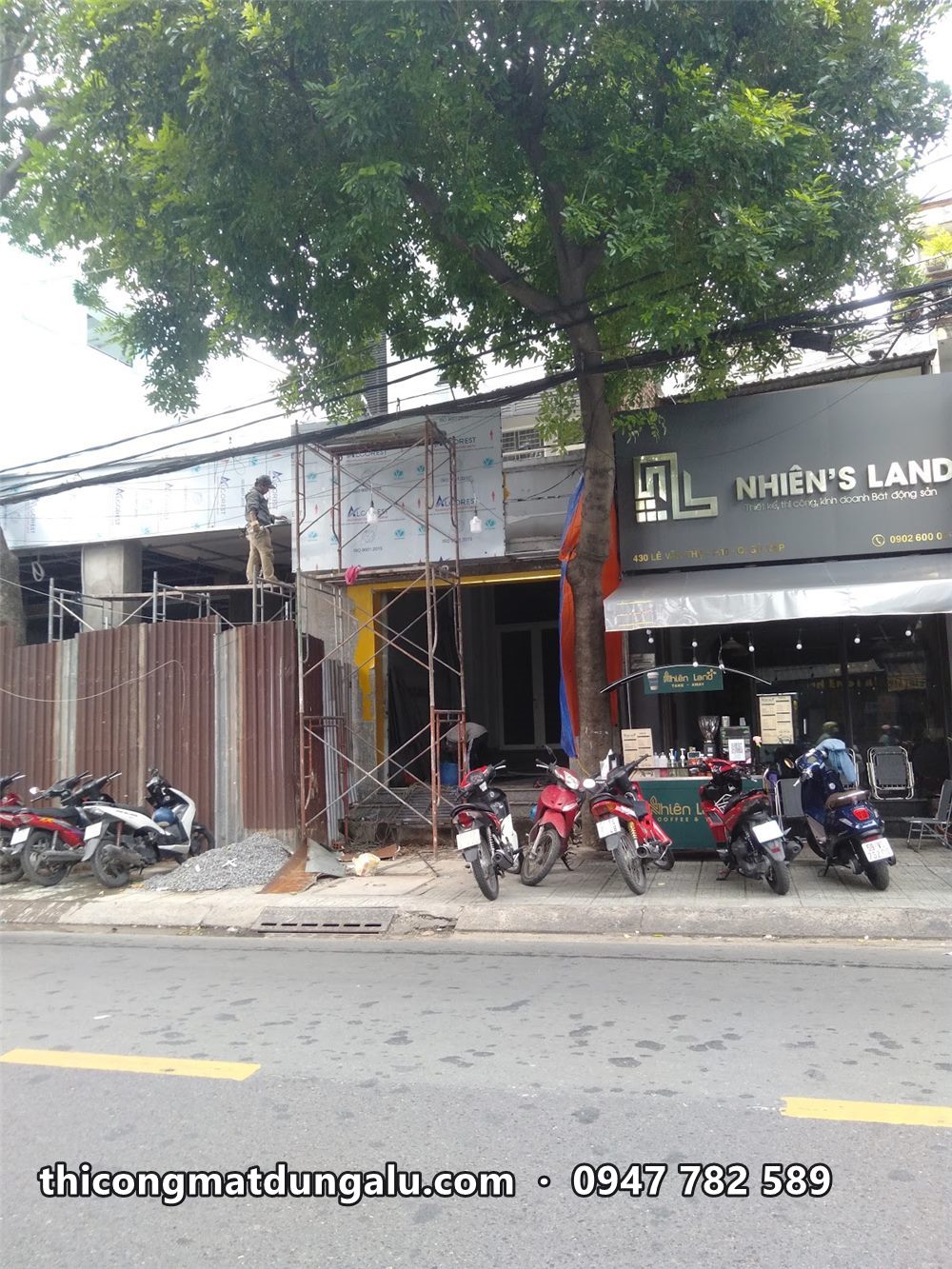 Mặt tiền nhà phố sau khi tháo biển cũ, giàn giáo dựng sẵn, xe máy đậu trước