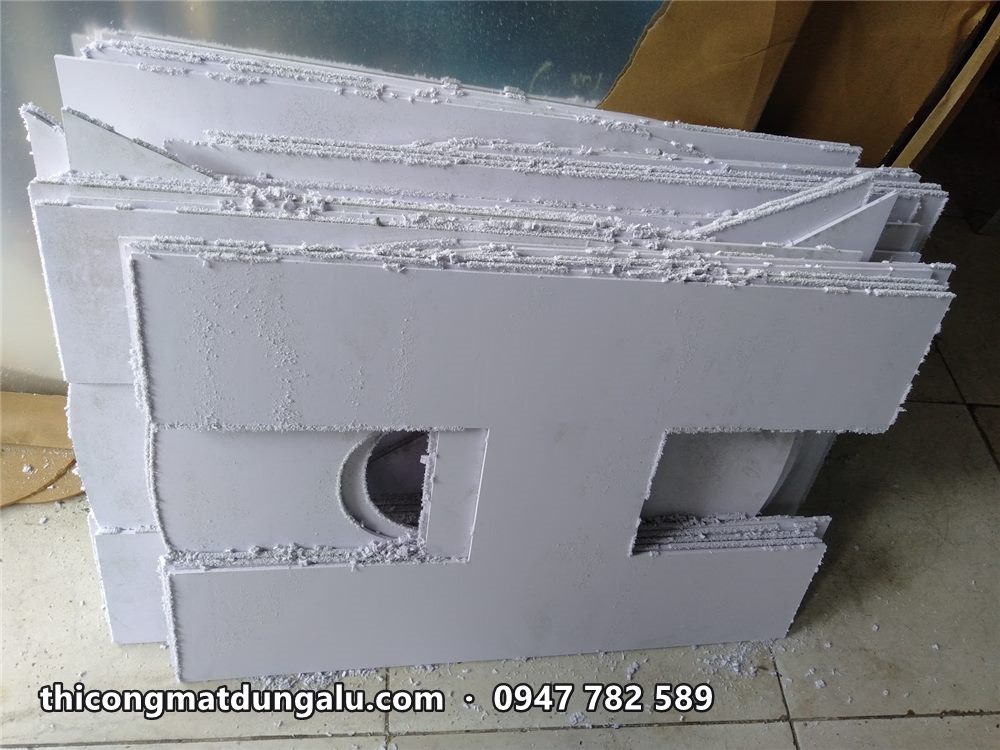 Các chữ cắt CNC từ tấm nhựa dày xếp chồng, nhìn rõ độ dày chữ