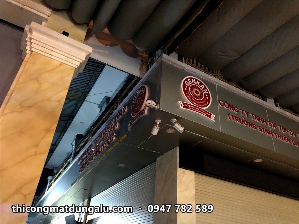 Góc biển với logo tròn và chữ đỏ dưới ánh đèn ban đêm