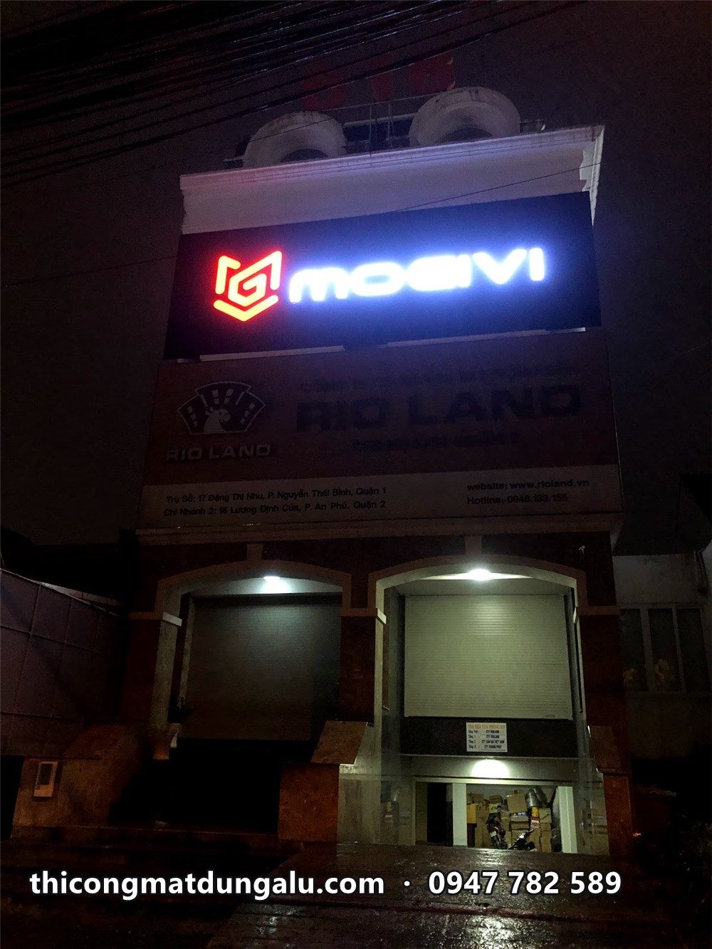 Bảng hiệu Mogivi sáng đèn ban đêm, logo đỏ chữ trắng
