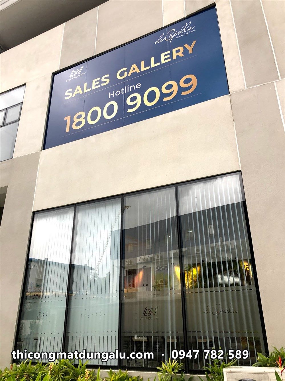 Biển Sales Gallery De Capella xanh đậm trên mặt tiền kính văn phòng