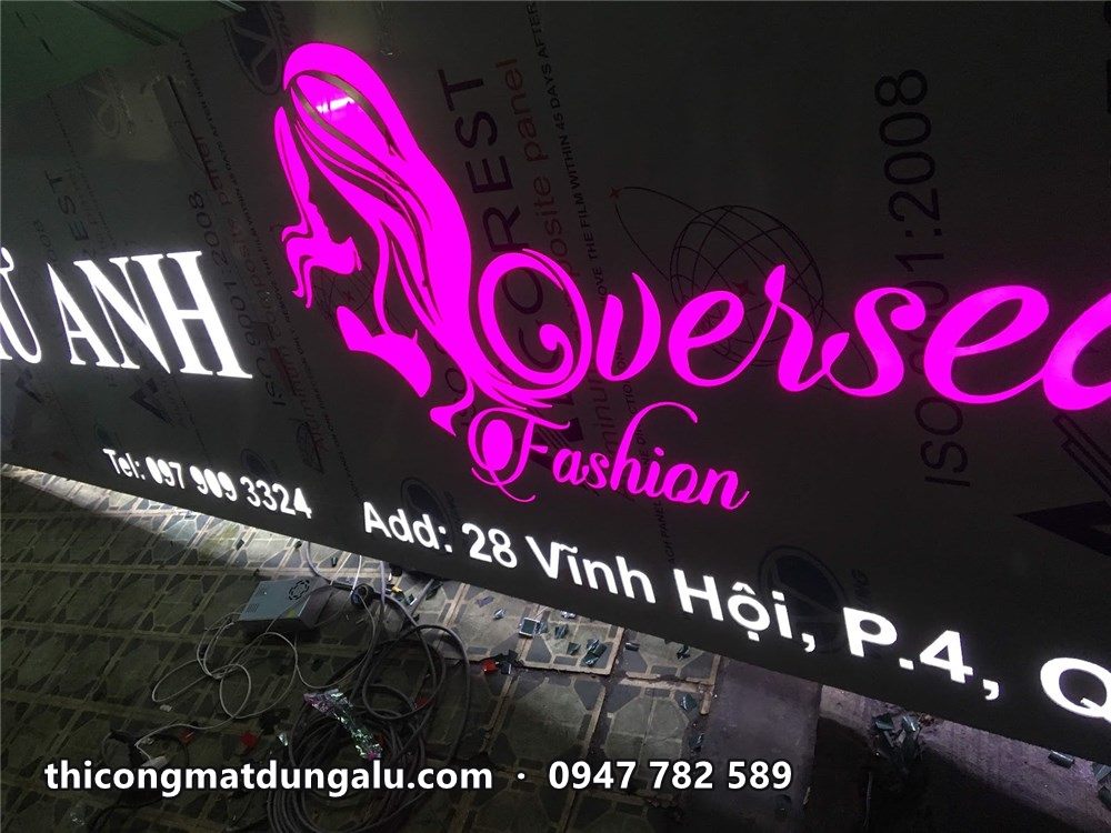 Logo Overseas Fashion hồng tím phát sáng và địa chỉ 28 Vĩnh Hội quận 4