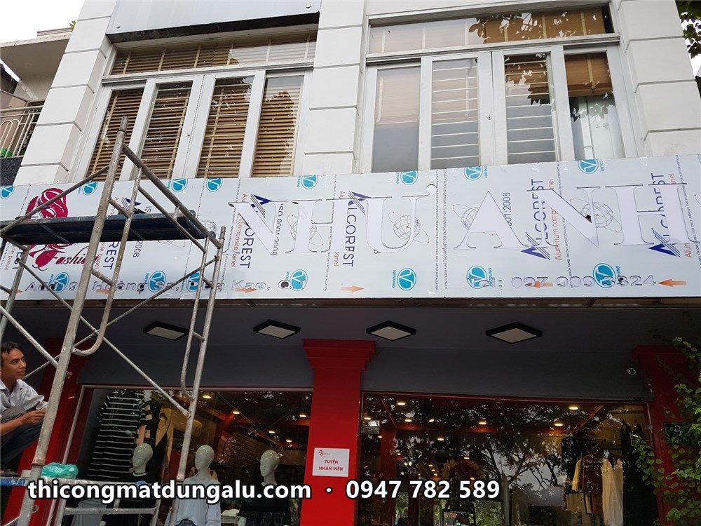 Mặt tiền shop thời trang đang ốp alu, tấm còn màng bảo vệ