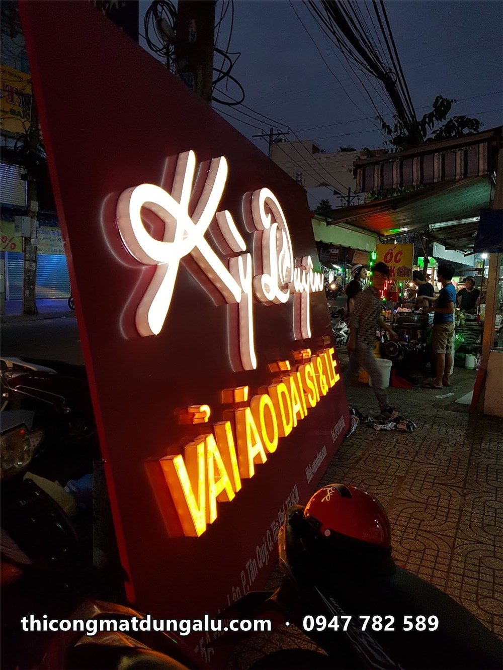 Chữ nổi Kỳ Duyên trắng và Vải áo dài vàng phát sáng nhìn từ dưới lên