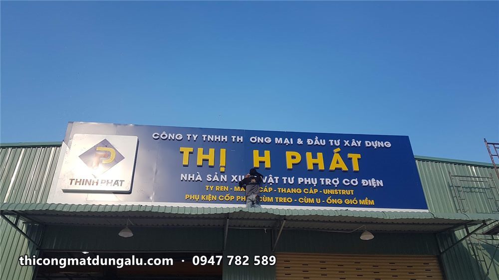 Bảng hiệu Thịnh Phát xanh dương chữ vàng lắp trên mái nhà xưởng dưới trời xanh