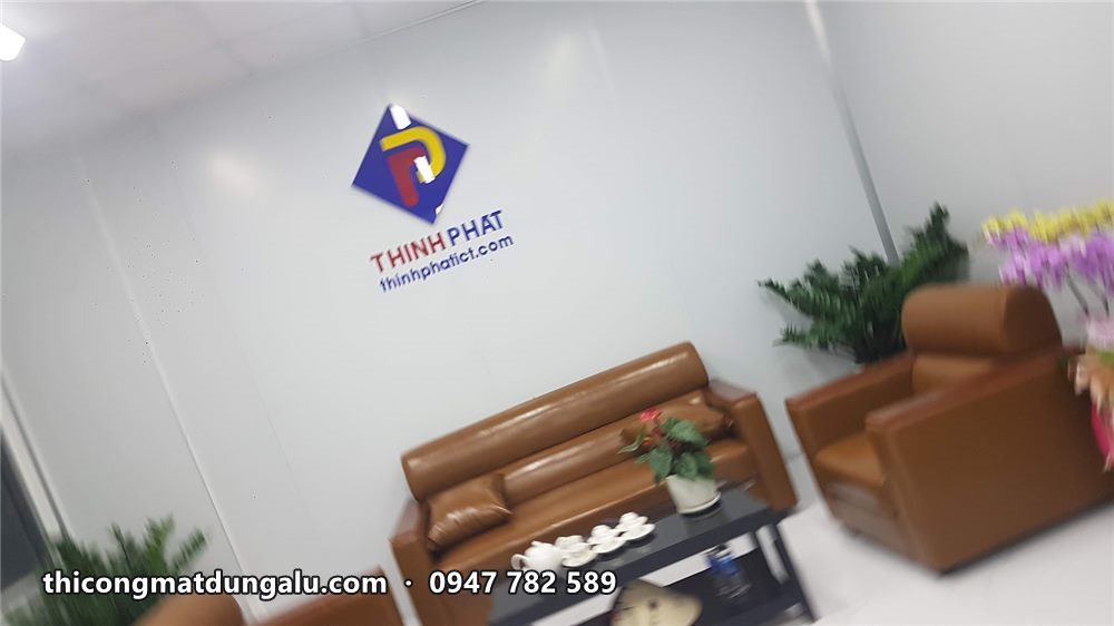 Phòng tiếp khách với logo Thịnh Phát, sofa da nâu, bàn trà và chậu cây