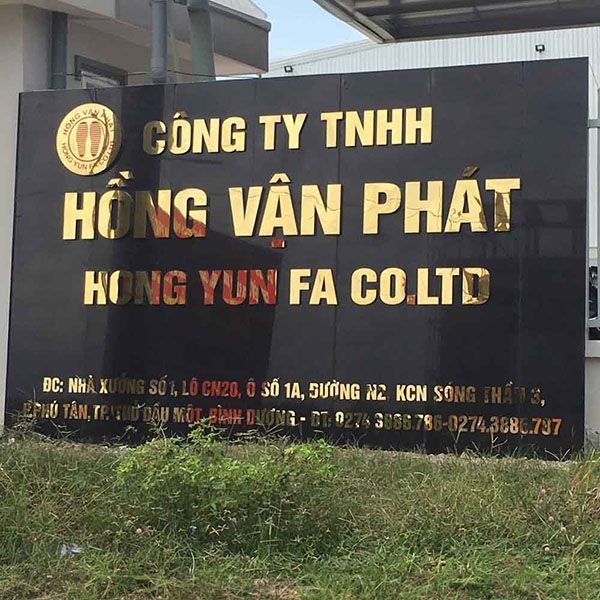 Biển tên Công ty TNHH Hồng Vận Phát chữ vàng trên nền đá đen đặt trước nhà xưởng