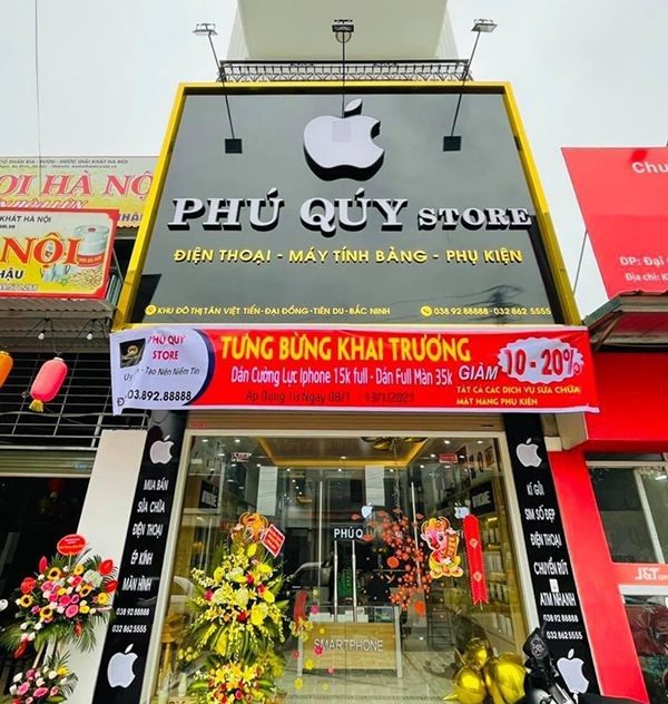 Mặt tiền cửa hàng Phú Quý Store với logo táo, chữ nổi trắng và viền vàng