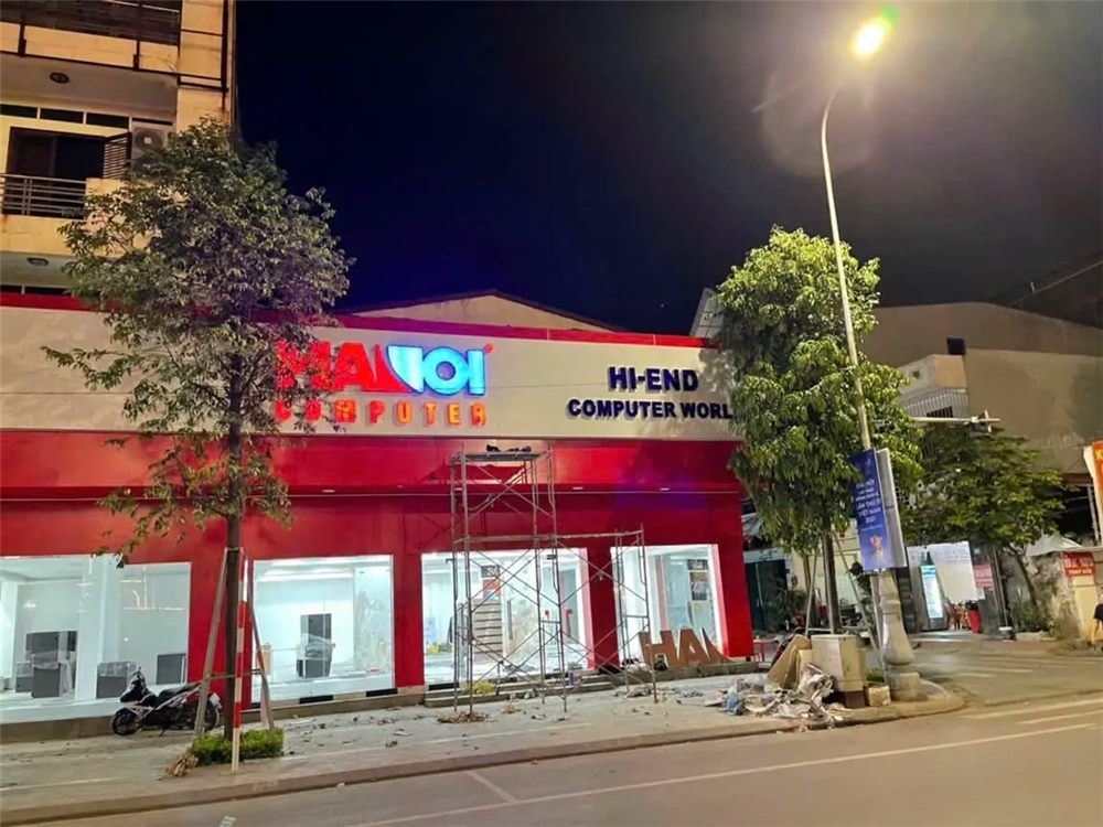 Cửa hàng máy tính gần hoàn thiện ban đêm, mặt dựng đỏ và chữ nổi sáng
