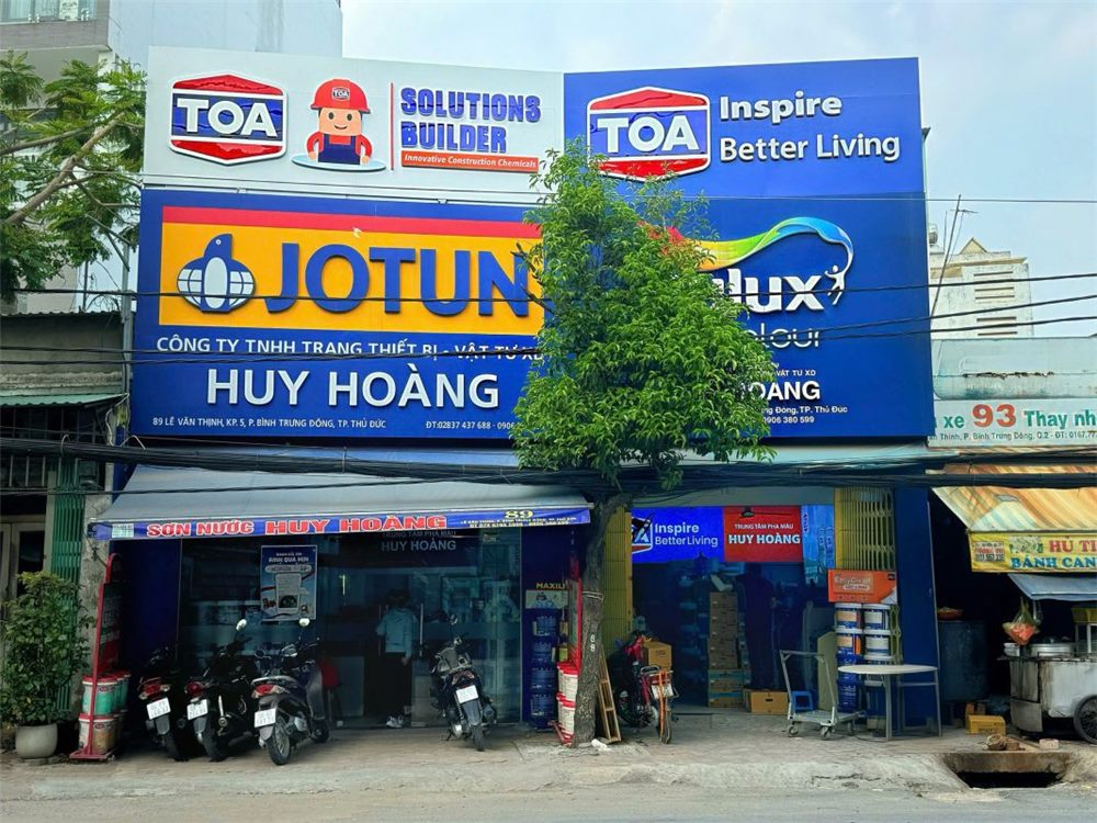 Mặt tiền đại lý sơn Huy Hoàng với các ô logo TOA, Jotun, Dulux và tên cửa hàng ở giữa
