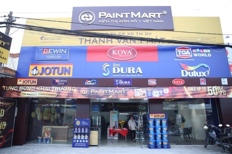 Mặt tiền siêu thị sơn với dải logo nhiều hãng và băng rôn khai trương giảm giá