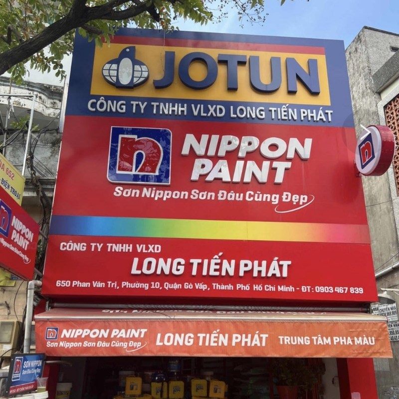 Bảng hiệu Jotun và Nippon Paint của công ty vật liệu xây dựng trên nền đỏ