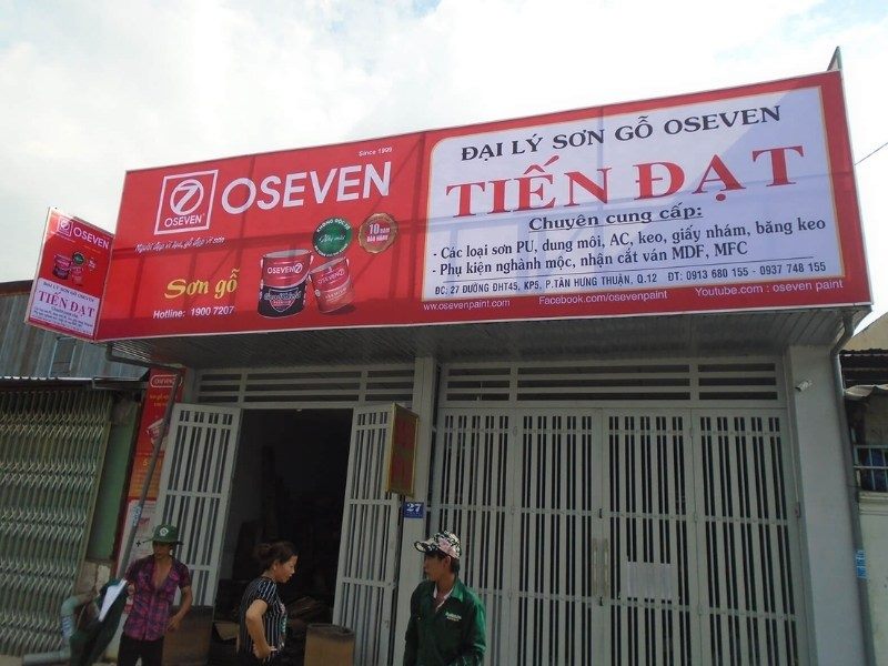 Đại lý sơn gỗ Oseven với bảng đỏ trắng liệt kê các loại sơn và phụ kiện