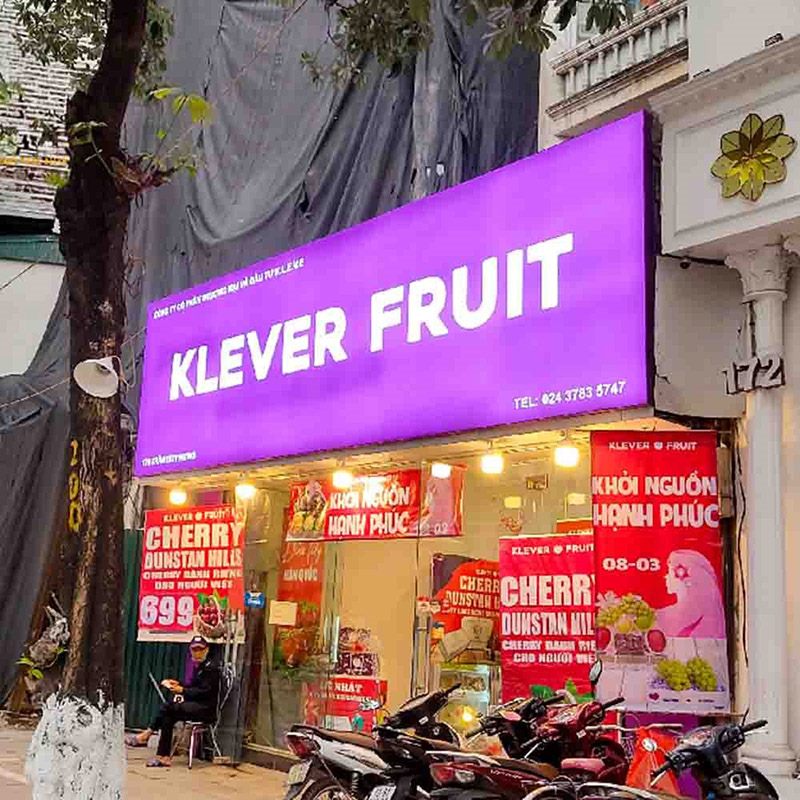 Cửa hàng Klever Fruit với bảng tím chữ trắng và cửa kính dán poster cherry