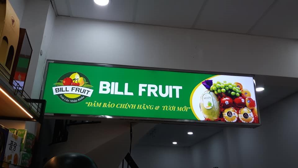 Hộp đèn Bill Fruit nền xanh lá với logo và hình trái cây in bên phải