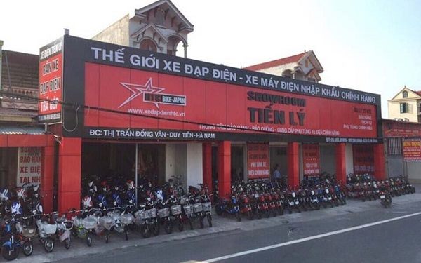 Showroom xe đạp điện mặt tiền dài ốp alu đỏ, bảng chữ chạy suốt và xe xếp dọc đường