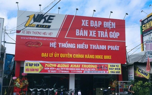 Bảng hiệu đại lý xe đạp điện nền đỏ trắng với logo hãng và dòng bán trả góp