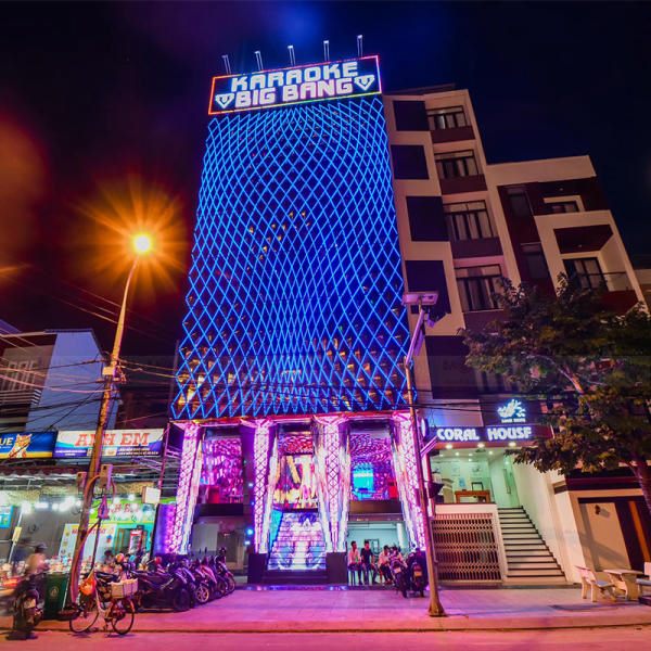 Tòa nhà karaoke nhiều tầng phủ lưới LED xanh và hồng về đêm