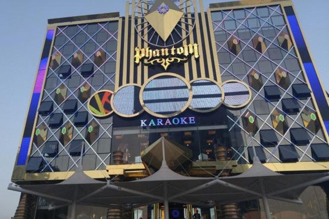 Mặt dựng karaoke với tấm ốp lưới kim cương và logo vàng