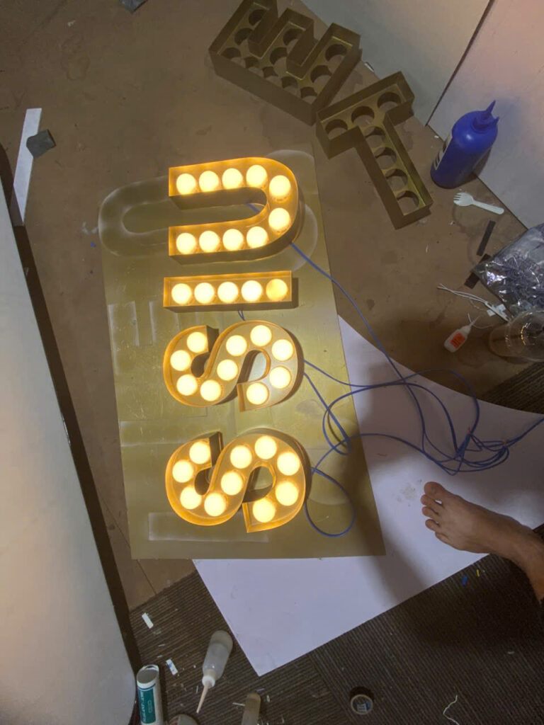Chữ bóng đèn đang gia công, bật thử đèn trên sàn xưởng