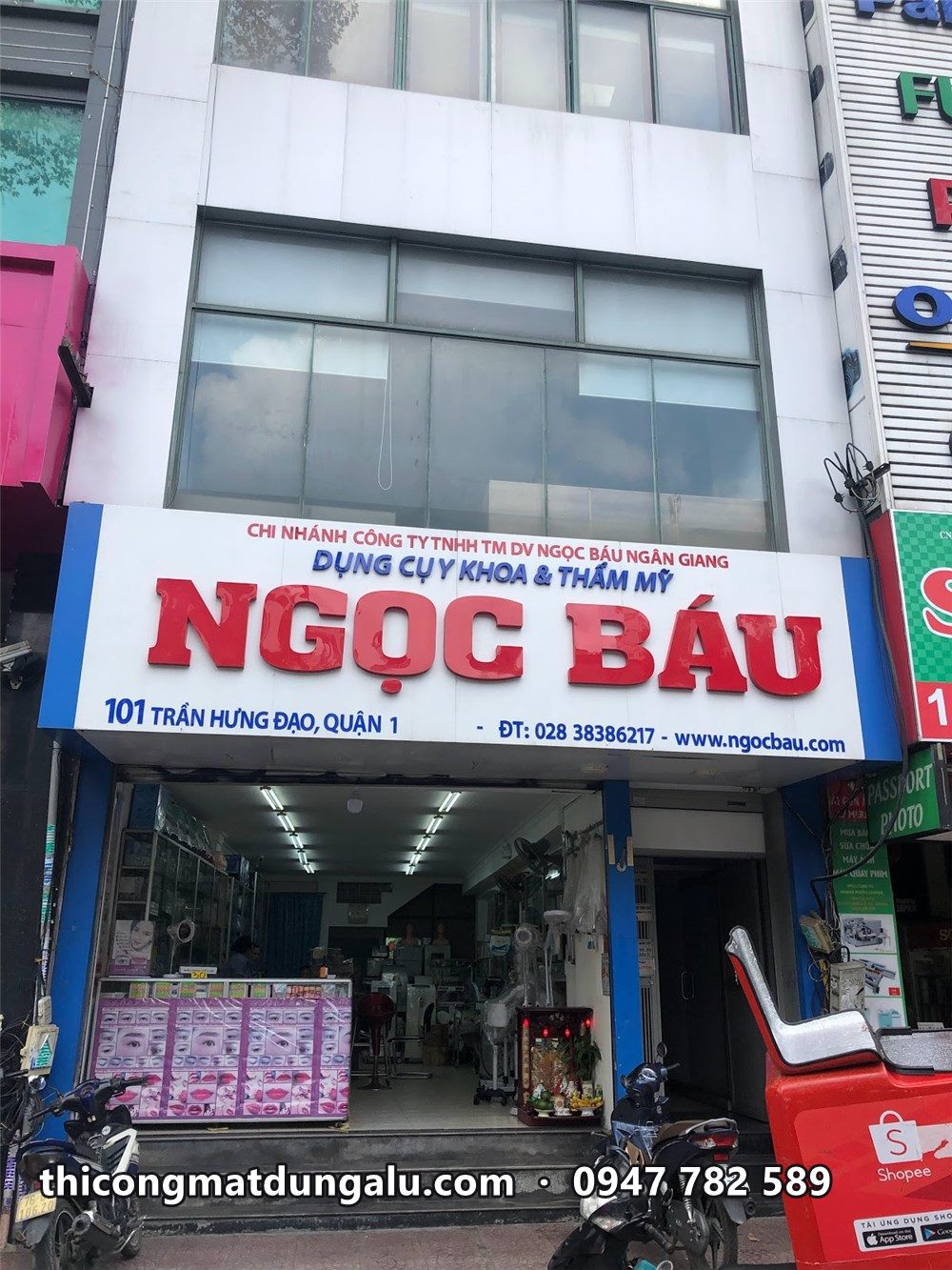 Mặt tiền tòa nhà với biển Ngọc Báu chữ đỏ nền trắng ở tầng trệt