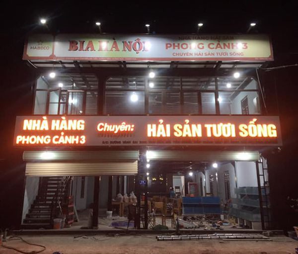 Nhà hàng hải sản về đêm, chữ nổi sáng mặt chạy dọc mặt tiền