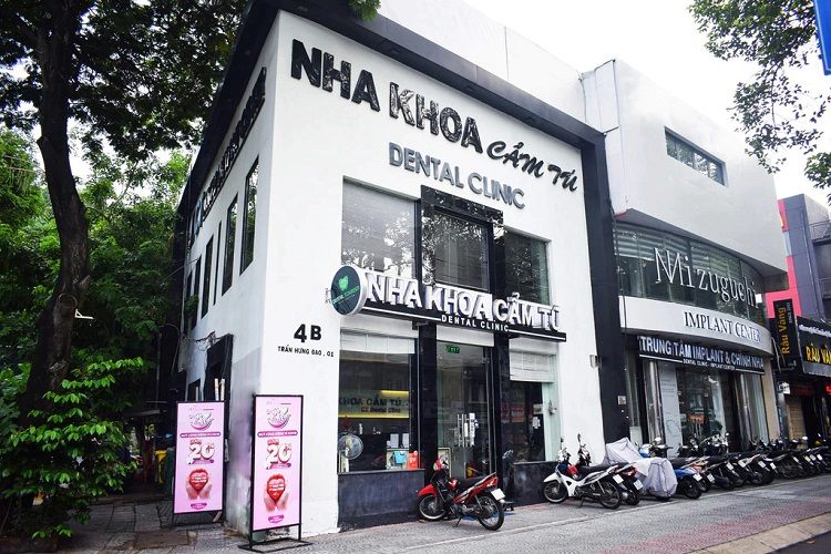 Tòa nhà nha khoa màu trắng với chữ nổi đen lớn chạy dọc