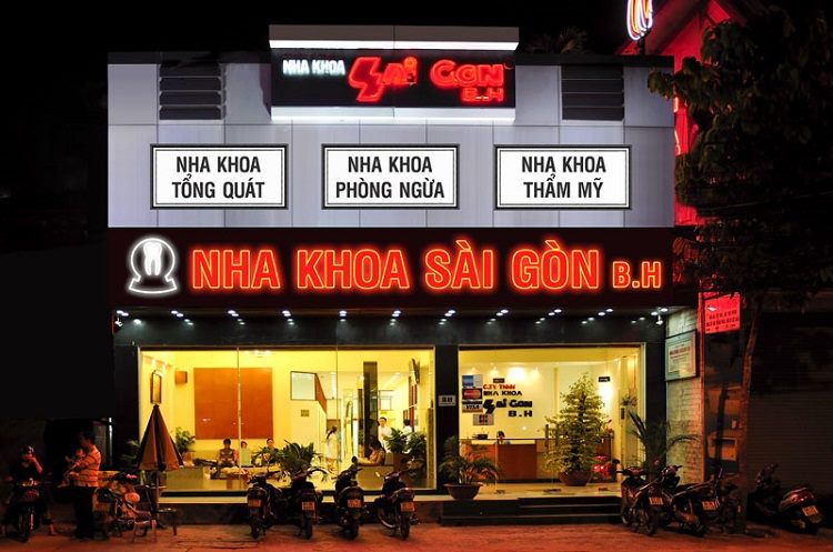 Nha khoa về đêm với chữ LED đỏ và ba ô dịch vụ phía trên