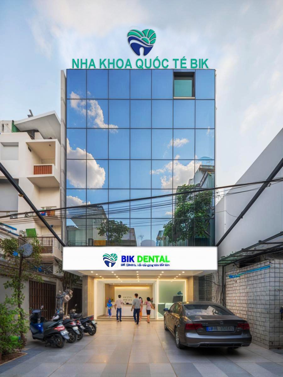 Tòa nhà nha khoa mặt kính với tên và logo trên đỉnh