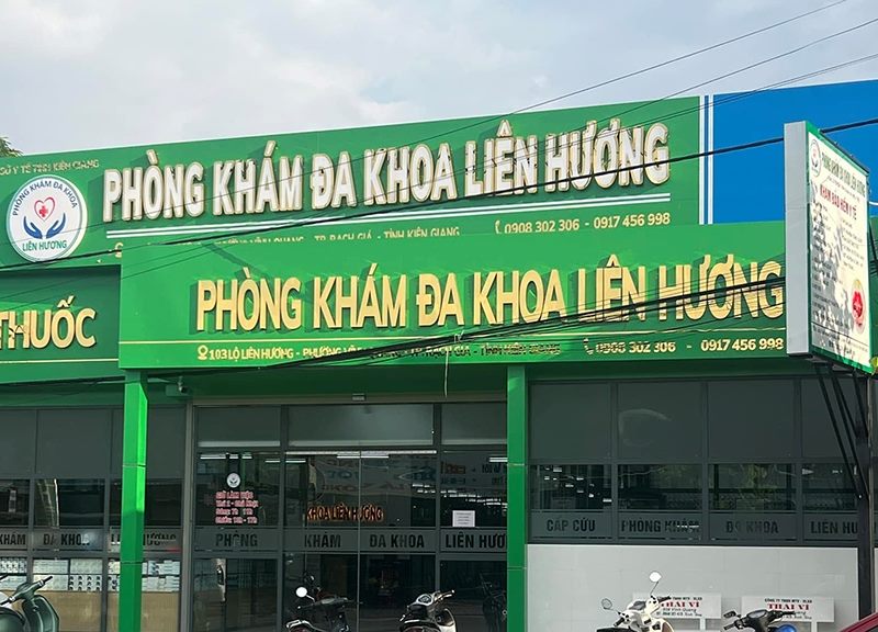 Phòng khám đa khoa với hai tầng bảng hiệu nền xanh lá chữ nổi trắng