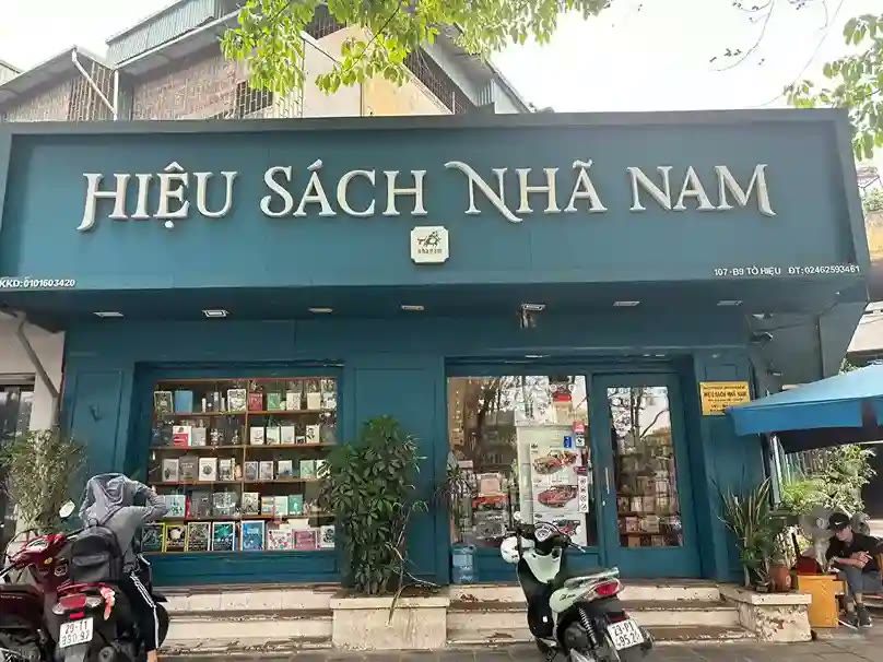 Hiệu sách Nhã Nam mặt tiền xanh rêu, chữ nổi trắng kiểu có chân và tủ sách sau cửa kính