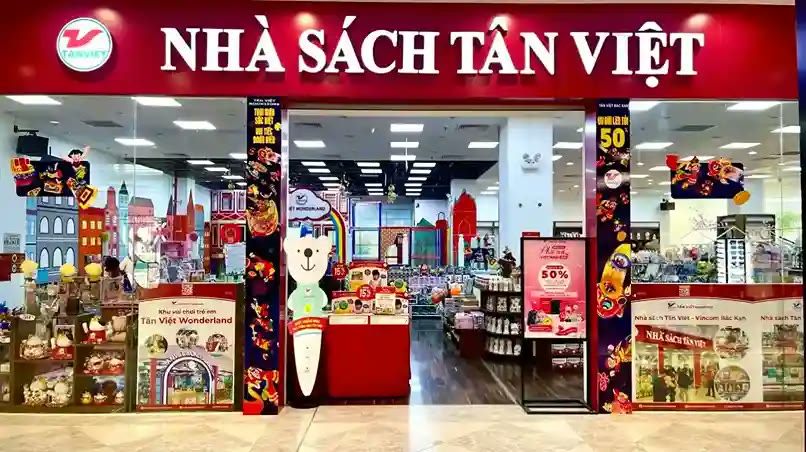 Nhà sách trong trung tâm thương mại với bảng đỏ chữ trắng và quầy trưng bày nhiều màu