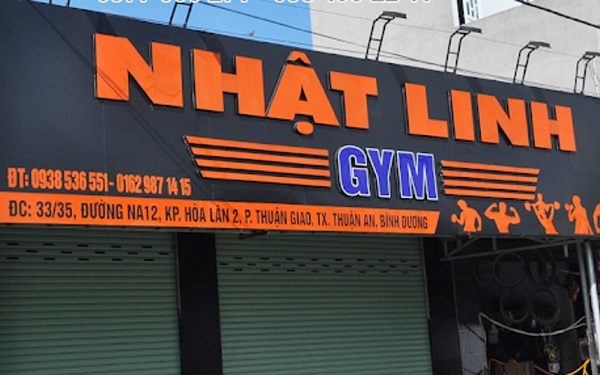Bảng hiệu phòng gym nền đen chữ nổi cam lớn và hình người tập
