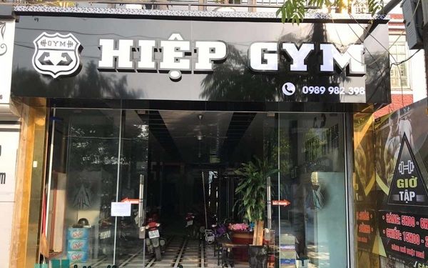 Phòng gym mặt tiền kính với chữ nổi trắng lớn trên nền đen