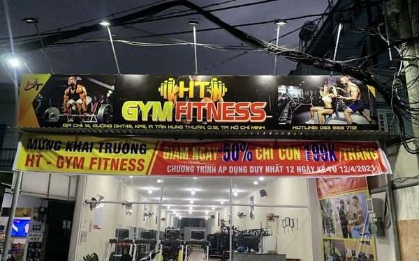 Phòng gym với bảng hiệu in hình và băng rôn khai trương giảm giá