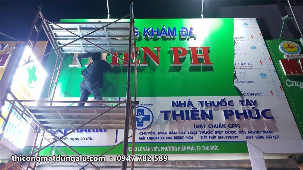Giàn giáo dựng trước mặt tiền xanh lá, thợ gắn chữ Thiên Phúc, bên dưới là biển nhà thuốc