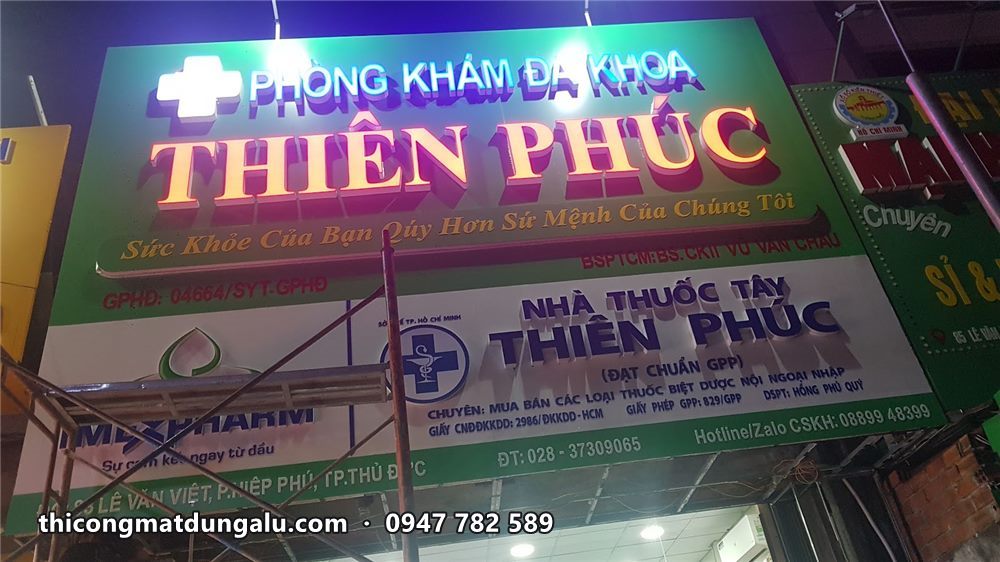 Chữ nổi Thiên Phúc màu đỏ viền vàng sáng đèn trên nền alu xanh, bên dưới là biển nhà thuốc
