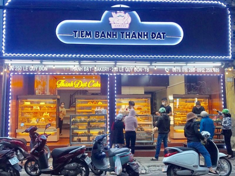 Tiệm bánh về đêm với bảng hiệu viền LED và tủ bánh chiếu sáng