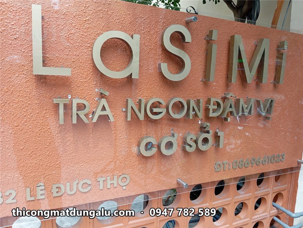 Chữ inox LaSimi Trà ngon đậm vị gắn nổi trên tường gạch cam có lỗ tròn