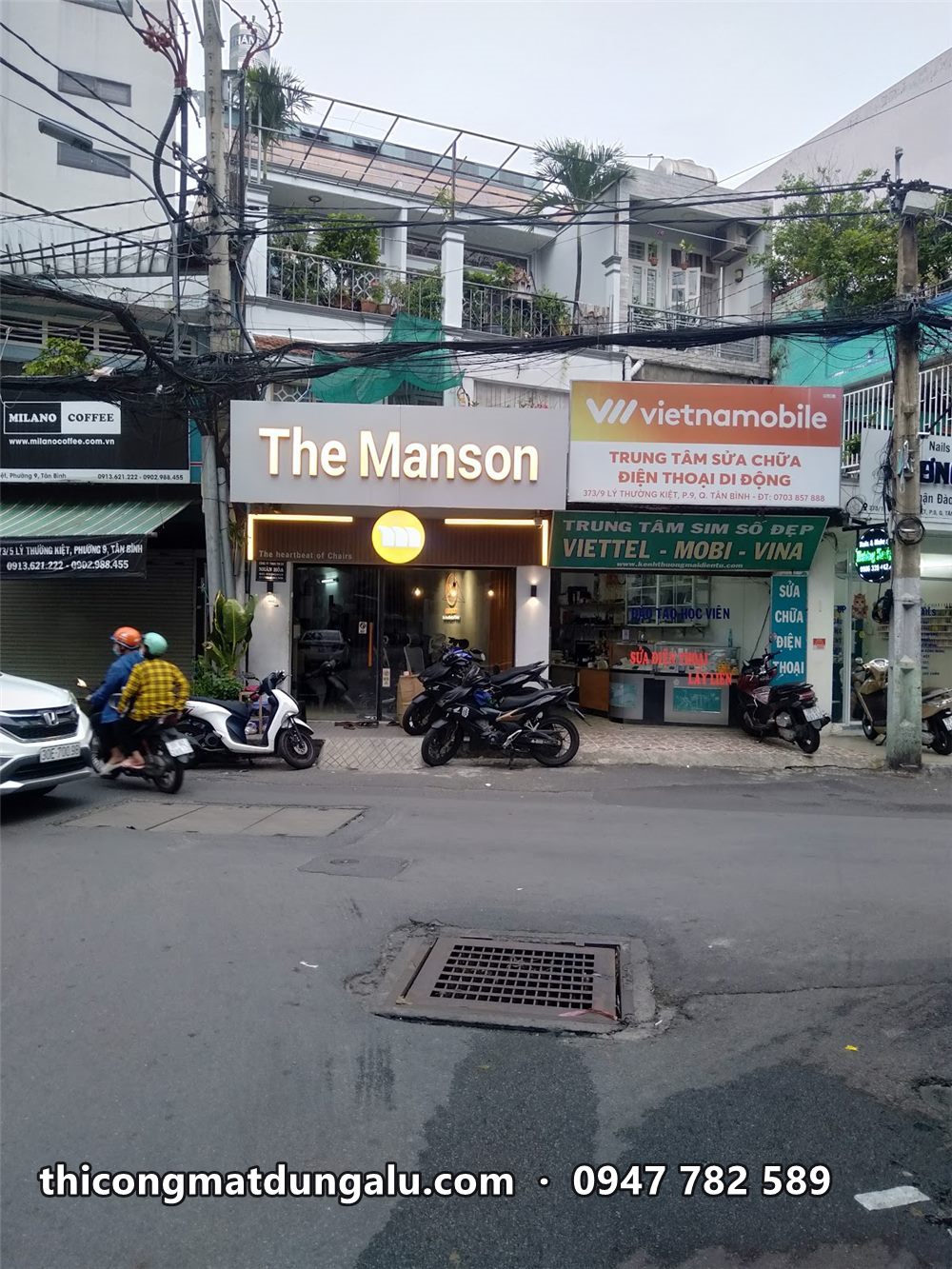 Mặt tiền The Manson với bảng chữ trắng trên nền xám trên con phố đông xe