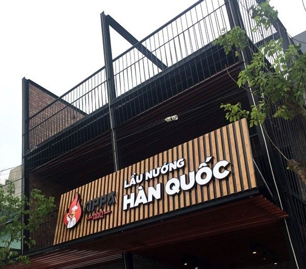 Bảng hiệu lẩu nướng Hàn Quốc trên nền lam gỗ, khung sắt đen phía trên
