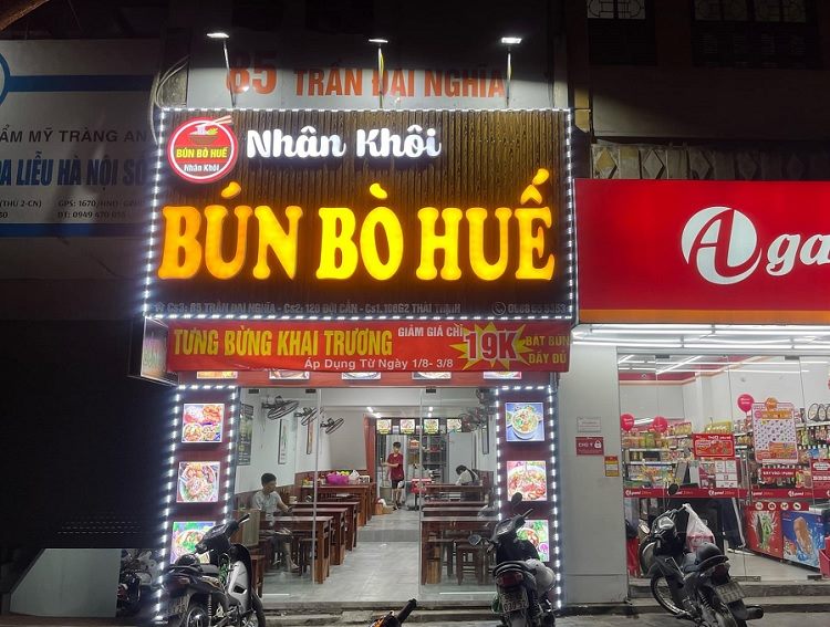 Bảng hiệu bún bò Huế Nhân Khôi chữ nổi vàng sáng, viền đèn LED và băng rôn khai trương