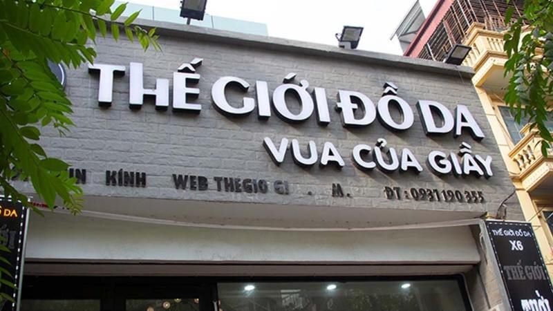 Bảng hiệu Thế giới đồ da chữ nổi trắng trên nền ốp đá xám