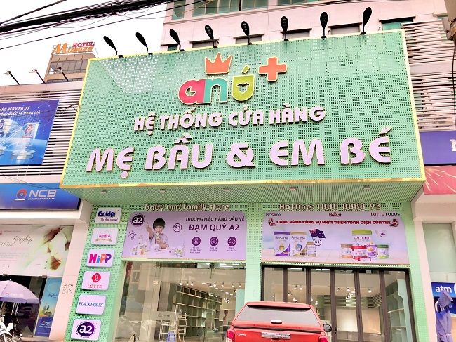 Mặt tiền hệ thống cửa hàng mẹ bầu và em bé nền xanh mint, chữ nổi hồng trắng