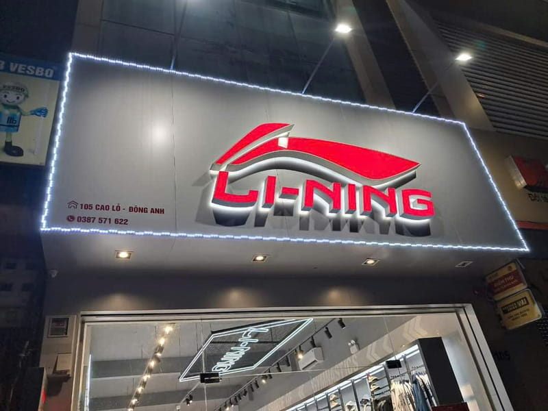 Bảng hiệu Li-Ning nền xám đen, logo chữ nổi đỏ trắng và viền LED