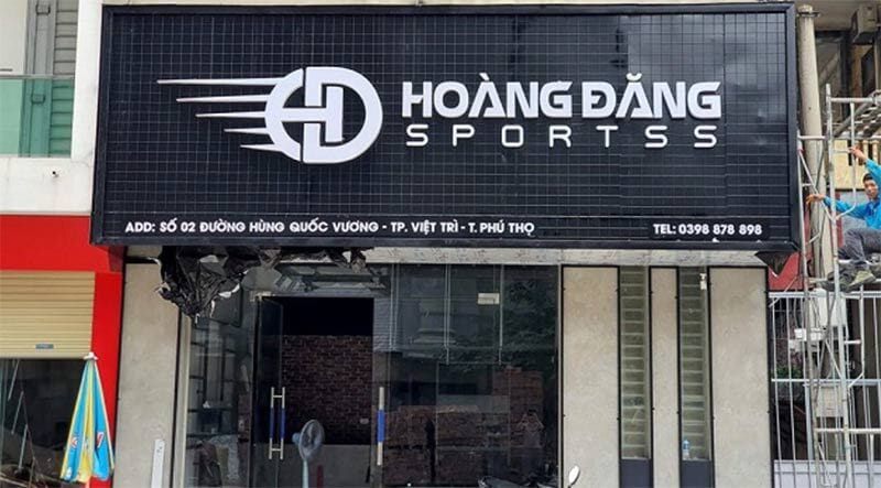 Bảng hiệu Hoàng Đăng Sports nền đen, logo chữ HD có vệt tốc độ