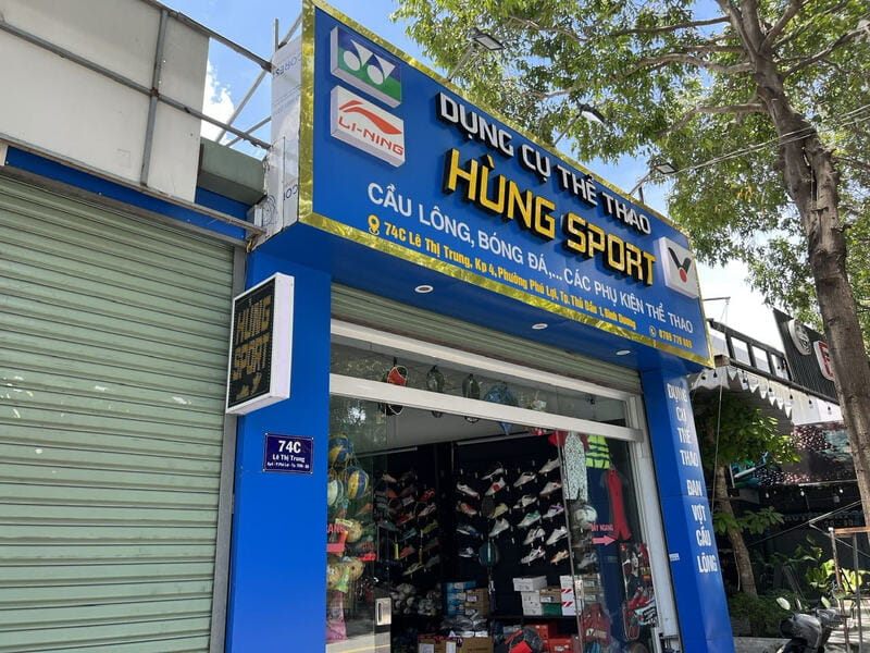 Mặt tiền cửa hàng dụng cụ thể thao Hùng Sport nền xanh dương, logo các hãng
