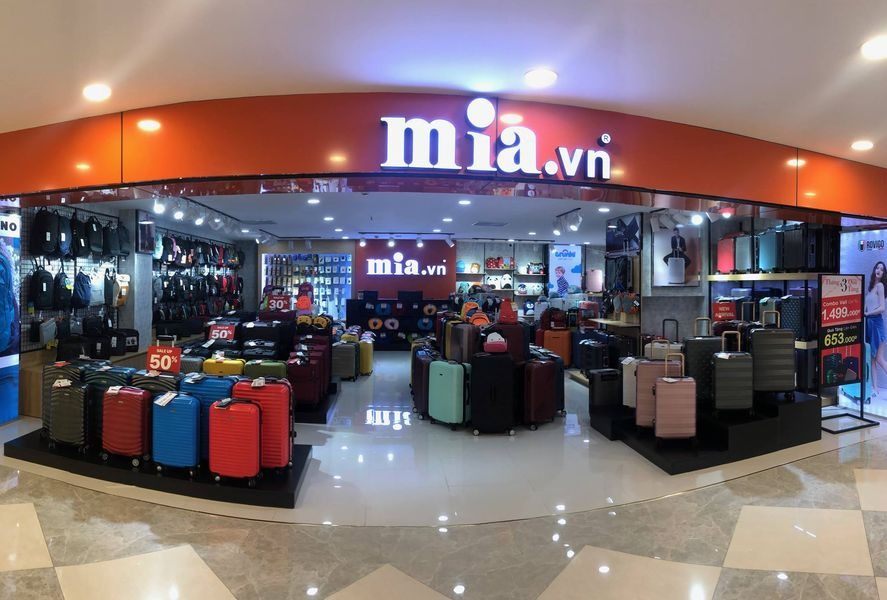 Gian hàng vali mia.vn trong trung tâm thương mại với mái vòm cam và chữ nổi trắng