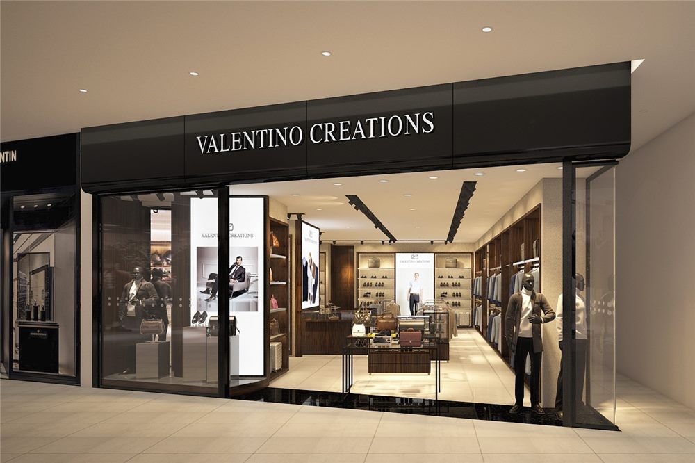 Phối cảnh mặt tiền Valentino Creations ốp đen với chữ nổi trắng mảnh và cửa kính lớn